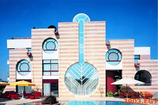 Striking modern building with horizontal stripes, circular windows, and a central keyhole-shaped glass entrance.